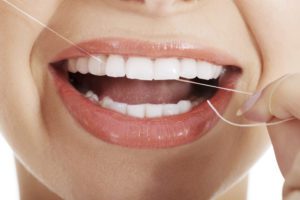 Young beautiful woman with dental floss preventative dentistry dentist in Virginia Beach Virginia
