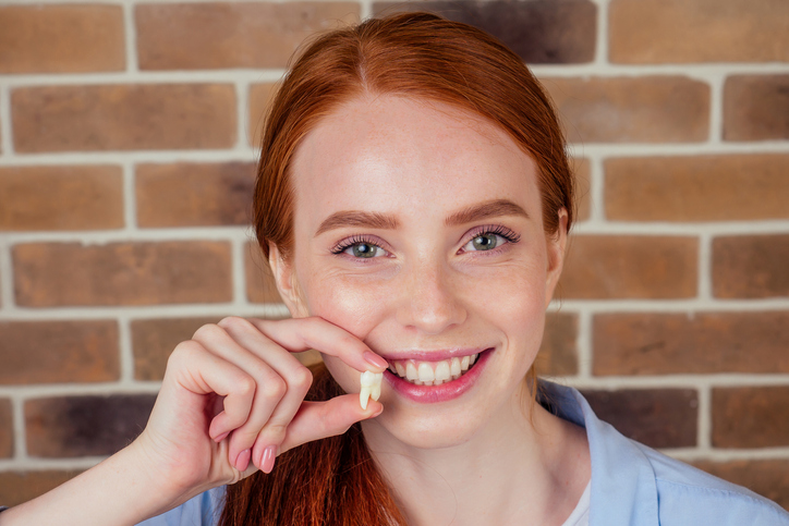 Woman holding her extracted tooth